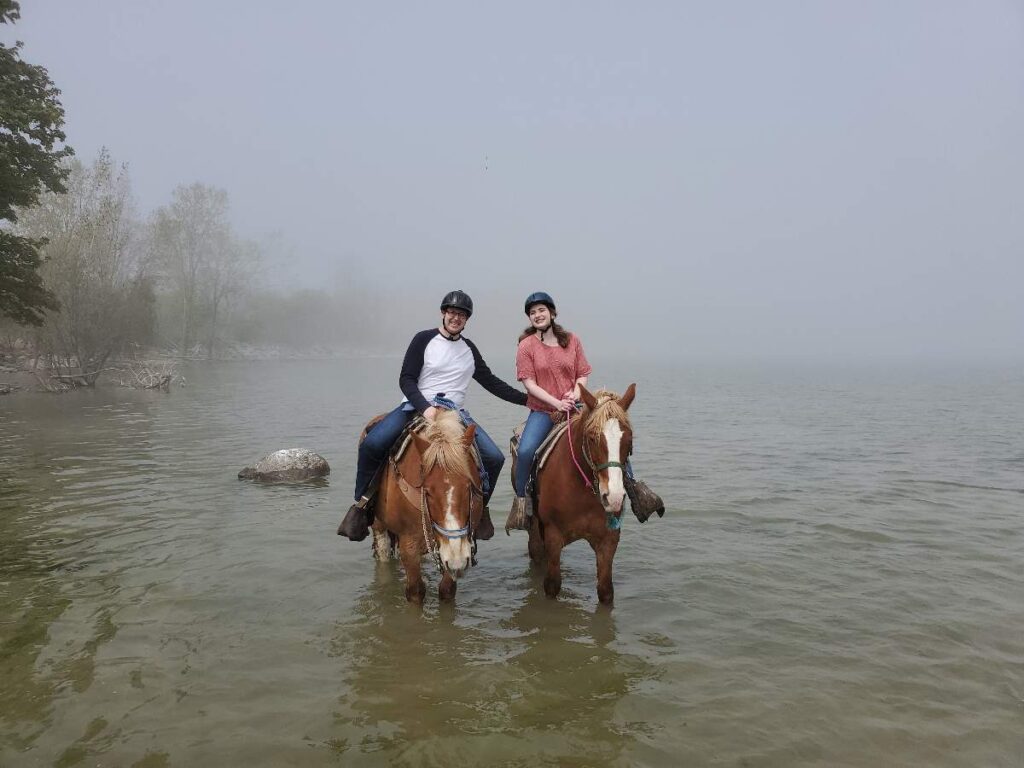 Couple horseback riding in the water
