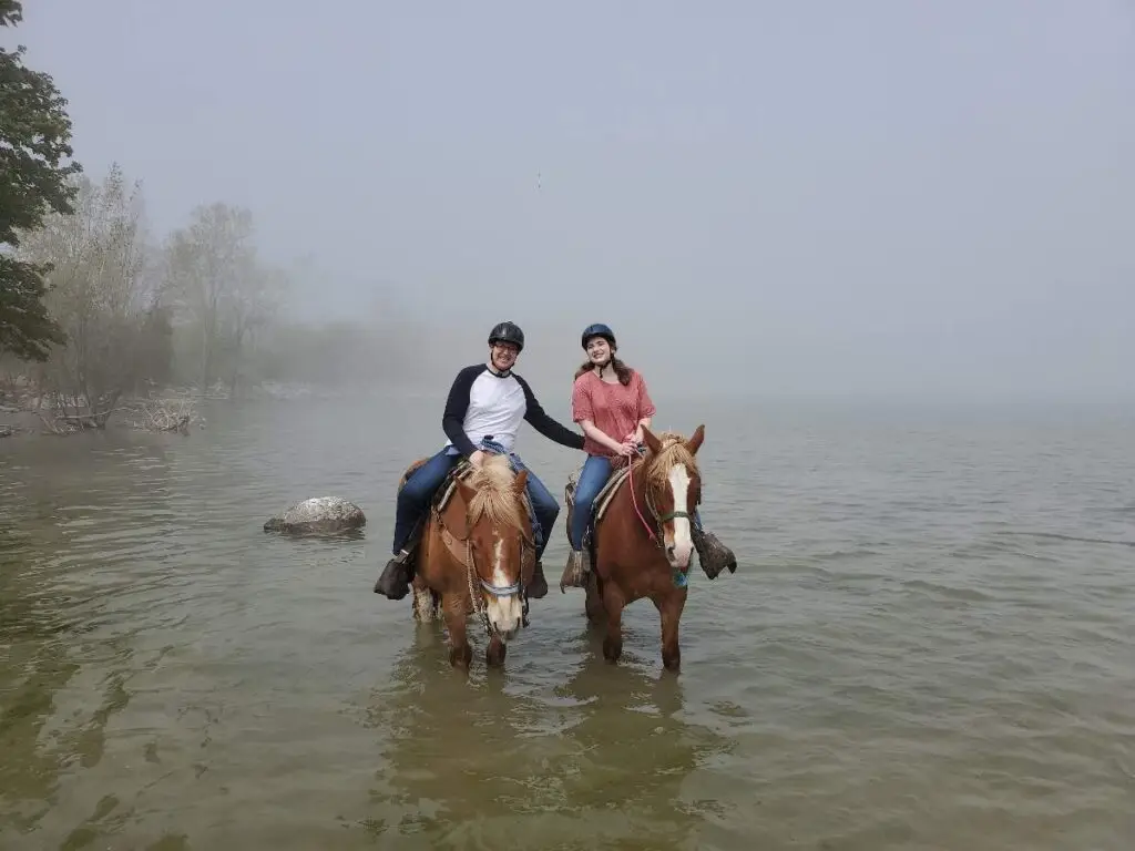 Couple horseback riding in the water