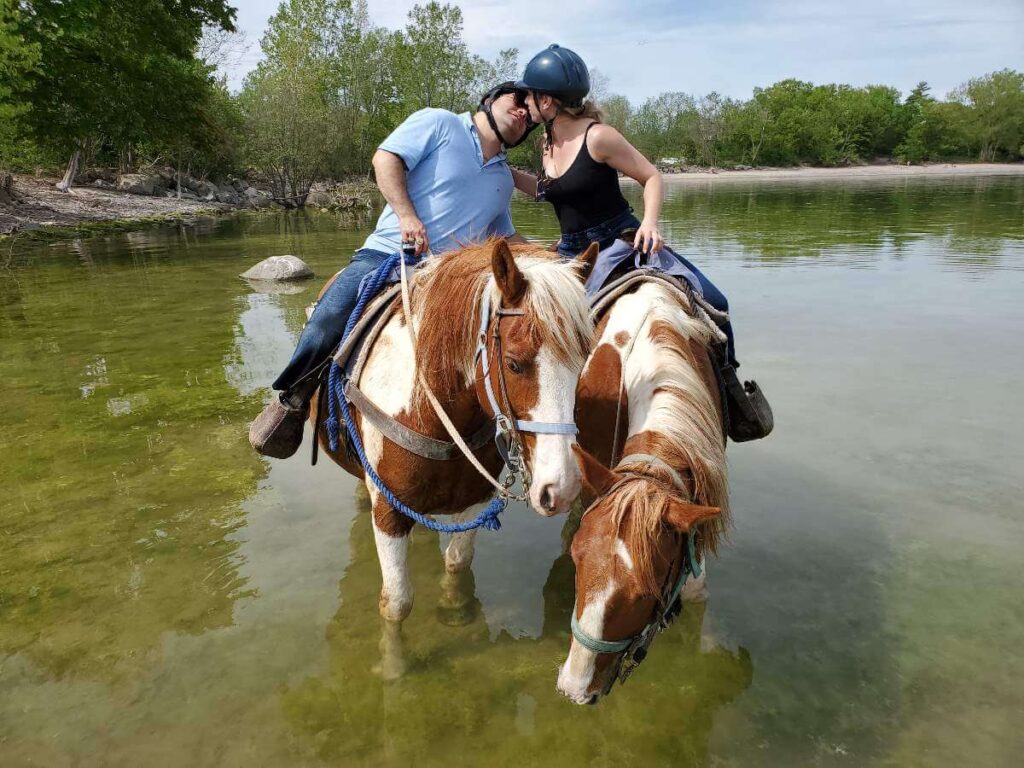 Couple kissing on horseback in water