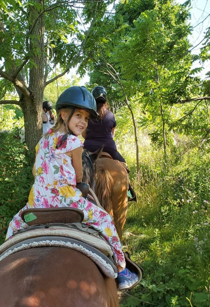 Child horseback riding in the forest