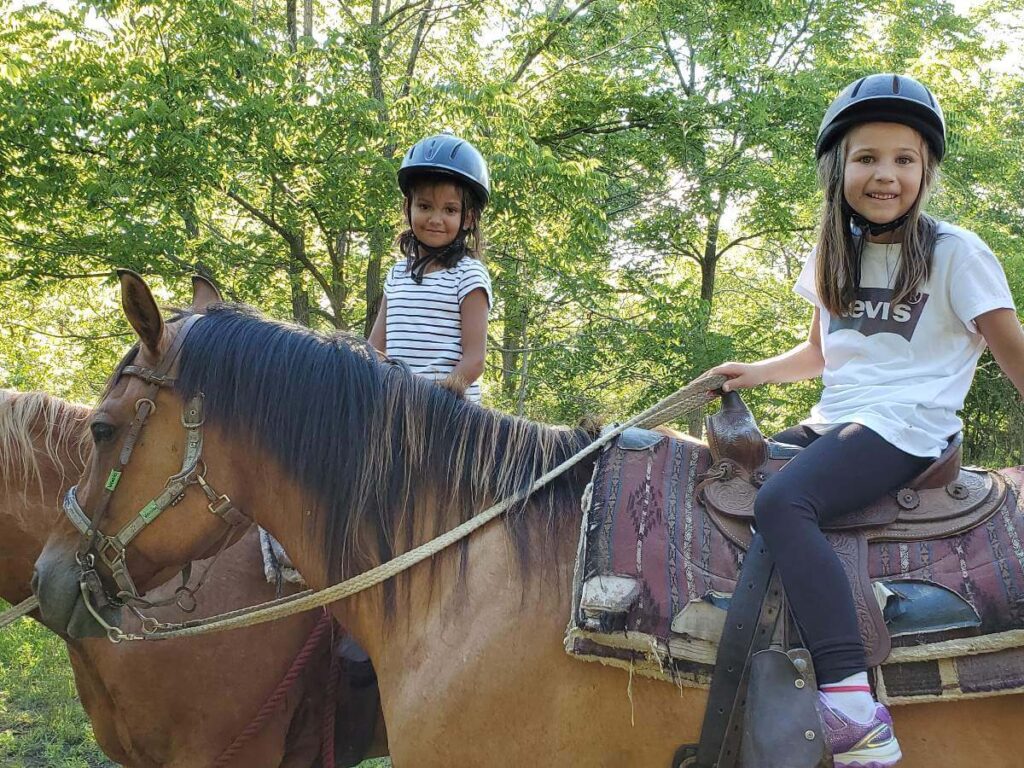 Two young trail riders from Toronto posing on their horses