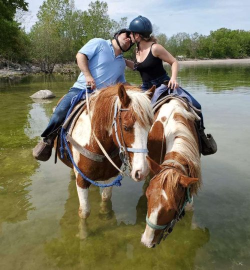 Couple kissing on horseback in water